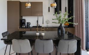 een keuken met een zwart aanrecht en grijze stoelen bij Liine apartment 3027 in Pärnu