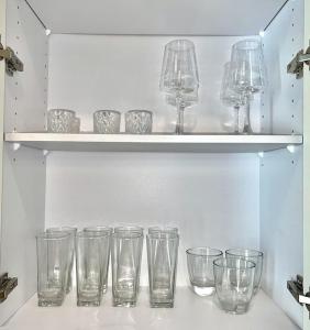 a row of empty glasses sitting on a shelf at Dreamy Pink Resort Style Oasis in Channelside in Tampa