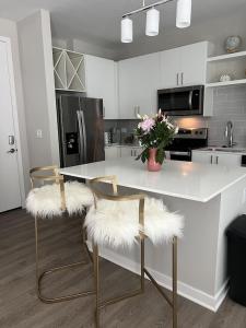 una cocina con una mesa con 2 sillas de piel blanca en Dreamy Pink Resort Style Oasis in Channelside, en Tampa