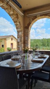 una mesa de madera con copas de vino en el patio en VAL D'ORCIA DELUXE 3, incantevole casa con vista sulle colline, WiFi e parcheggio en San Giovanni dʼAsso