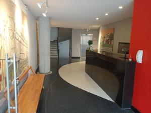 a lobby with a reception desk and a red wall at Alto 61 Apartamentos in Bogotá