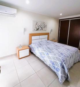 um quarto com uma cama com um edredão azul e branco em Blue Beach em Portimão