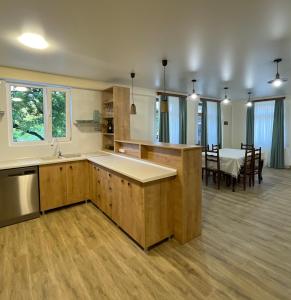 uma cozinha com armários de madeira e uma sala de jantar com uma mesa em Zaali's wine cellar em Vani