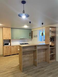 a large kitchen with wooden cabinets and a counter top at Zaali's wine cellar in Vani
