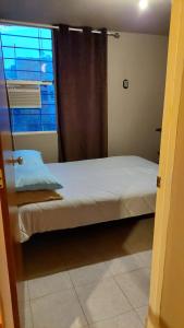 um pequeno quarto com uma cama e uma janela em RELAJACION SERCAS DEL AEROPUERTO 