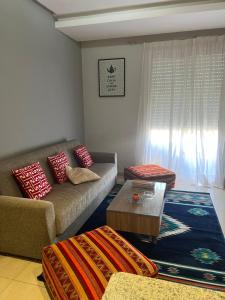 a living room with a couch and a coffee table at Jolie appartement avec piscine in Agadir