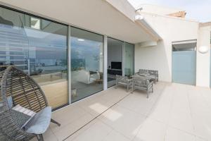 una sala de estar con ventanas de cristal y un patio. en Benalmadena Penthouse Bliss, en Benalmádena