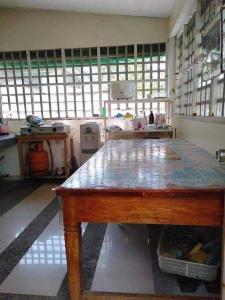 uma cozinha com uma mesa num quarto com janelas em Room In Lobo Triple N Homestay 2nd N 