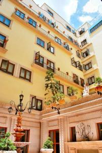 a large yellow building with windows and a fountain at Emporio Zacatecas in Zacatecas