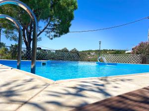 a blue swimming pool with a slide in it at Vasilikos Apartments in Paralia Agias Foteinis