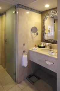 a bathroom with a sink and a shower with a mirror at Emporio Zacatecas in Zacatecas