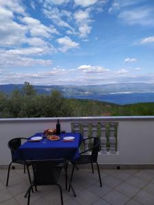 d'une table bleue et de chaises sur un balcon avec vue. dans l'établissement Apartmani Danica, à Vrbnik