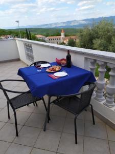 a table with a plate of food on a balcony at Apartmani Danica in Risika