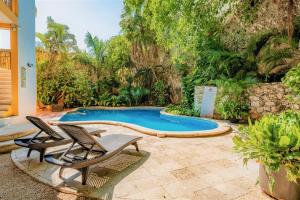 a patio with two chairs and a swimming pool at Maison del Embajador in Mérida