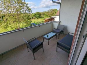 three chairs and a table on a balcony with a view at S'bahnhöfle Apartments in Ringsheim