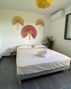 a bedroom with a bed with two umbrellas on the wall at VOIR com 5 étoiles airb, Villa Zolenzo, la tête dans les montagnes, 10 pers in Petit-Bourg