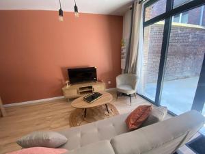 sala de estar con sofá blanco y mesa en Appart 1 chambre neuf confort, en Rouen