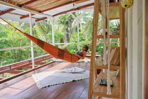 a woman laying in a hammock in a house at Casa BOHÖ in Puerto Viejo