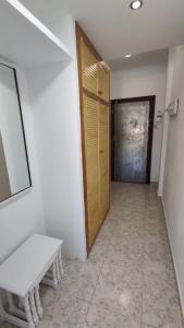 un pasillo con una puerta y un banco en una habitación en Apartamento en Costacabana, en El Alquián