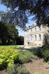 een groot wit gebouw met een tuin ervoor bij Les Deux Marguerite in Alençon