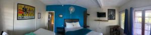 1 dormitorio con cama y pared azul en Kingsworth Bed and Breakfast, en Kingston