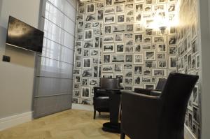 un ristorante con sedie nere e un muro di immagini di Place 24 Suites & Wellness a Roma