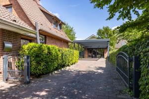 a driveway leading to a building with a gate at Ferienhaus Baumann in Quickborn