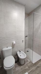 uma casa de banho com um WC, um chuveiro e um lavatório. em Apartamento en Costacabana em El Alquián