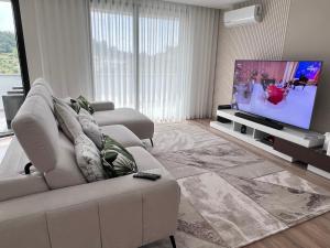 ein Wohnzimmer mit einem weißen Sofa und einem Flachbild-TV in der Unterkunft Castelo View in Pombal