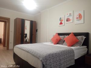 a bedroom with a bed with orange and gray pillows at Clove Boutique House Apart in Akcaabat