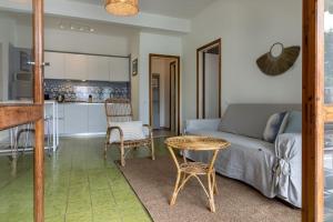 un soggiorno con divano e tavolo e una cucina di Il Giardino tra Cielo e Mare a Portovenere