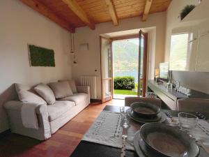 ein Wohnzimmer mit einem Sofa und einem Tisch in der Unterkunft Regina di Laglio - Free Parking, Garden, Lake View in Laglio