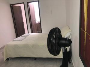 een slaapkamer met een bed en een ventilator aan de muur bij Apartamento cómodo, céntrico y bien ubicado apto 404 in Medellín