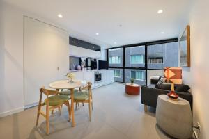 a living room with a table and a couch at The Canvas Apartment Hotel in Melbourne