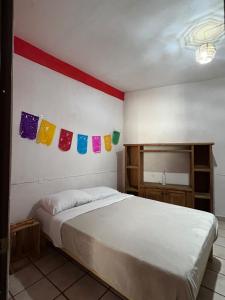 a bedroom with a bed with colorful flags on the wall at Home Sweet Home Guanajuato in Guanajuato