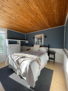 a bedroom with a bed with a wooden ceiling at Three Peaks Banff in Banff
