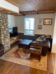 a living room with a leather couch and a table at Three Peaks Banff in Banff