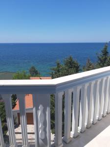 een wit balkon met de oceaan op de achtergrond bij Guest house Perović in Sutomore