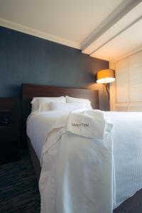 ハプナビーチにあるジ ウェスティン ハプナ ビーチ リゾートのホテルルーム 白いシーツ付きのベッド2台付