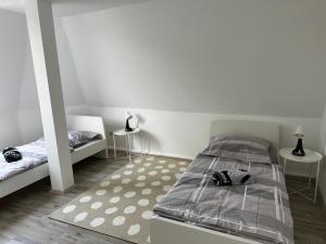 een slaapkamer met 2 bedden en 2 tafels bij A&V Apartments Schöne Dachgeschoss Wohnung in Gelsenkirchen