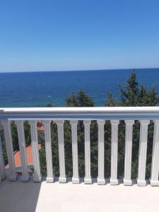 a white railing with the ocean in the background at Guest house Perović in Sutomore