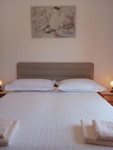 - un lit avec 2 oreillers blancs et un tableau mural dans l'établissement Studio with balcony, à Jelsa