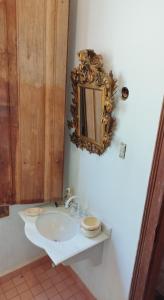a bathroom with a sink and a mirror on the wall at Fazenda Cachoeira Grande in Vassouras