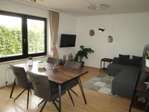 sala de estar con mesa, sillas y sofá en Apartment "Lavendel Garten", en Klein-Winternheim