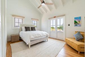 ein weißes Schlafzimmer mit einem Bett und einer Couch in der Unterkunft Casa de Luz and The PoolClub at Mahogany Bay! in San Pedro + 7 Fotos