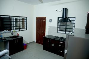 una cucina con lavello e frigorifero di Clover Home a Thiruvalla