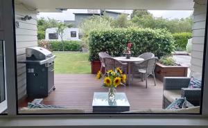 Elle offre une vue sur une terrasse avec une table et des chaises. dans l'établissement Hidden Gem, à Greytown