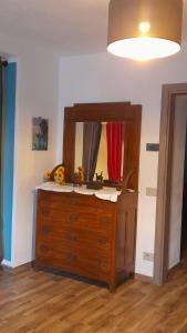 a wooden dresser with a mirror on top of it at Casa Luisa in Alba