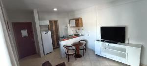 a small kitchen with a desk and a television in it at Apart Victoria in Vitória da Conquista
