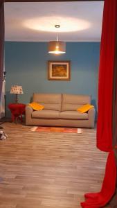 a living room with a couch and a blue wall at Casa Luisa in Alba